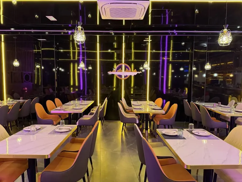 Salón principal del Restaurante OISHI con iluminación nocturna y mesas dispuestas
